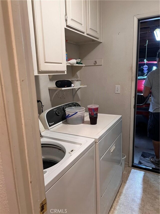 14106 Dartmouth St, Hesperia, CA 92344 - laundry room featuring separate washer and dryer, light tile patterned flooring, and cabinet space