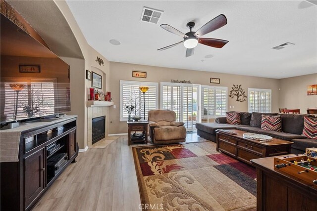 1410 Charles St, Banning, CA 92220 - living room with a ceiling fan, a fireplace, and light wood finished floors