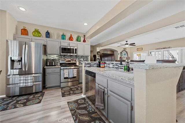 1410 Charles St, Banning, CA 92220 - kitchen featuring stainless steel appliances, gray cabinets, ceiling fan, light stone counters, and recessed lighting