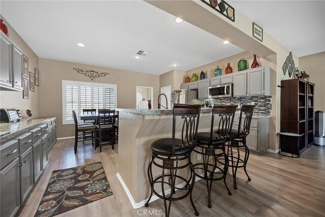 1410 Charles St, Banning, CA 92220 - kitchen with stainless steel appliances, light wood-type flooring, gray cabinetry, and recessed lighting