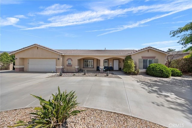 1410 Charles St, Banning, CA 92220 - view of front of house featuring concrete driveway, a garage, stucco siding, and a tiled roof
