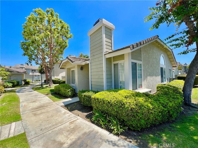 2014 W Hartford Pl Unit 58, Anaheim, CA 92801 - view of side of home featuring a chimney and stucco siding