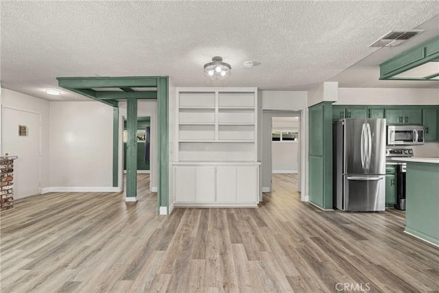 26865 Pine Canyon Rd, Lake Hughes, CA 93532 - kitchen with green cabinets, stainless steel appliances, light wood-style flooring, a textured ceiling, and light countertops