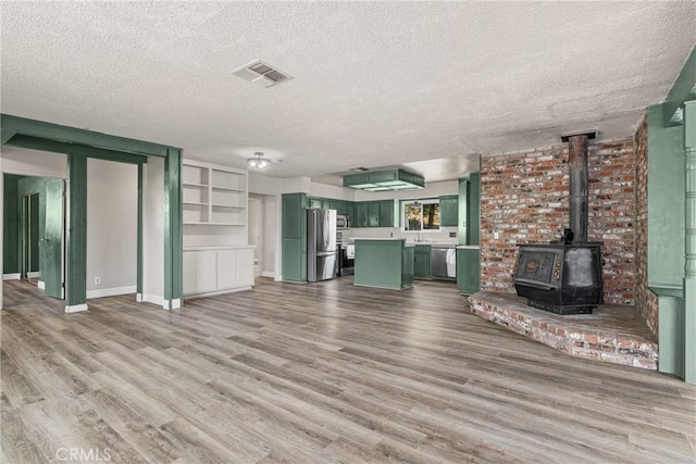 26865 Pine Canyon Rd, Lake Hughes, CA 93532 - unfurnished living room with a textured ceiling, wood finished floors, and a wood stove
