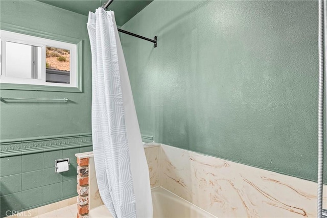 26865 Pine Canyon Rd, Lake Hughes, CA 93532 - full bathroom featuring a bathtub, a wainscoted wall, curtained shower, and tile walls
