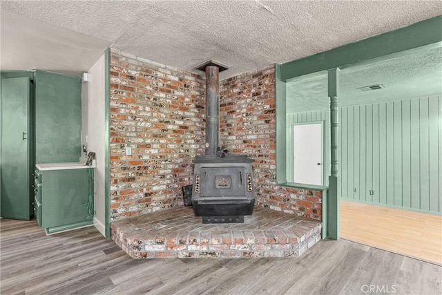 26865 Pine Canyon Rd, Lake Hughes, CA 93532 - detailed view of a textured ceiling, wood finished floors, and a wood stove