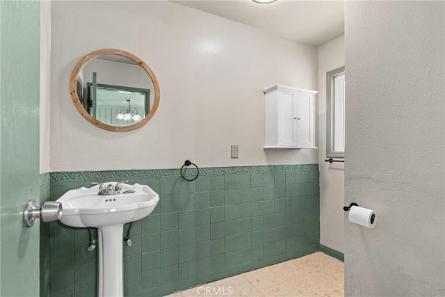 26865 Pine Canyon Rd, Lake Hughes, CA 93532 - bathroom featuring a wainscoted wall, tile walls, tile patterned floors, and a chandelier