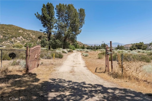 26865 Pine Canyon Rd, Lake Hughes, CA 93532 - view of road with a mountain view, a gate, and a gated entry