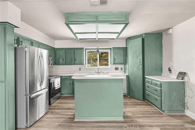 26865 Pine Canyon Rd, Lake Hughes, CA 93532 - kitchen with green cabinets, stainless steel appliances, light wood-style floors, and light countertops
