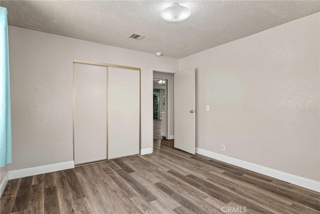 26865 Pine Canyon Rd, Lake Hughes, CA 93532 - unfurnished bedroom with wood finished floors, a closet, and a textured ceiling