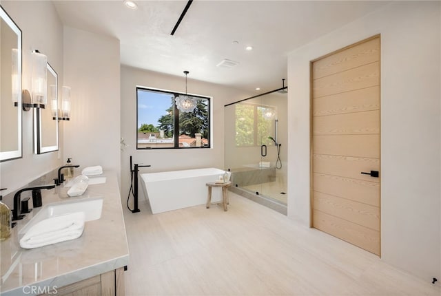 555 N Plymouth Blvd, Hancock Park, CA 90004 - bathroom featuring a stall shower, a freestanding bath, double vanity, and recessed lighting