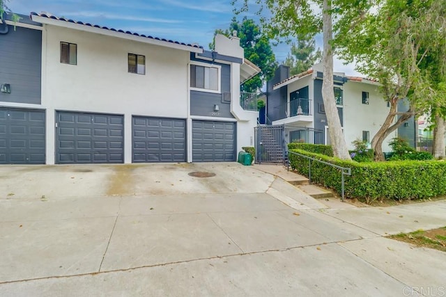 2917 C St Unit 186, San Diego, CA 92102 - view of side of home featuring a garage, concrete driveway, and stucco siding