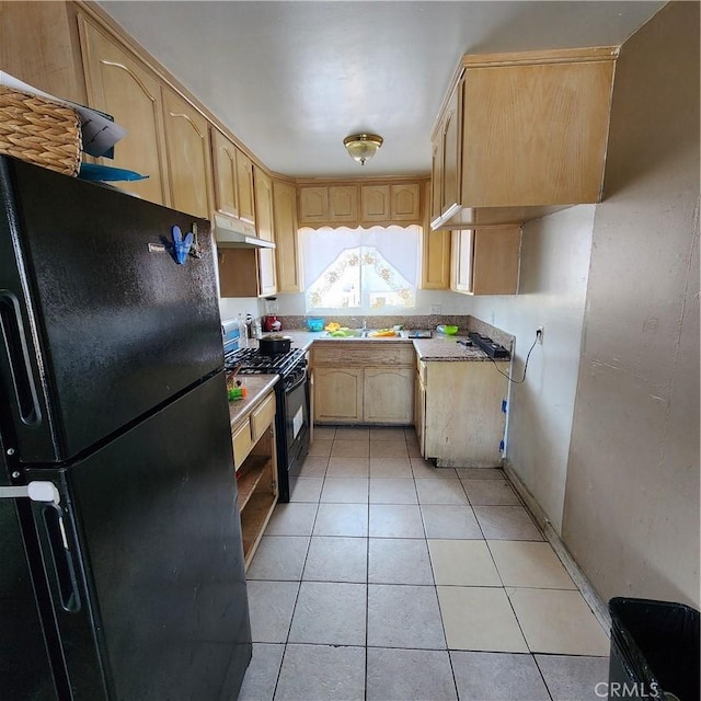 3322 E 8th St, Los Angeles, CA 90023 - kitchen with black appliances, under cabinet range hood, light brown cabinetry, light tile patterned floors, and light countertops