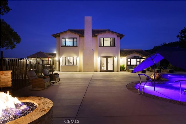 10270 Santa Ana Rd, Atascadero, CA 93422 - back of house at twilight with a fire pit, a patio area, stucco siding, and a chimney
