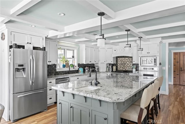 10270 Santa Ana Rd, Atascadero, CA 93422 - kitchen with appliances with stainless steel finishes, backsplash, beamed ceiling, light stone counters, and light wood-style floors