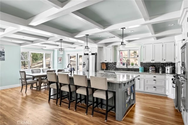 10270 Santa Ana Rd, Atascadero, CA 93422 - kitchen with coffered ceiling, stainless steel fridge, an island with sink, backsplash, and white cabinets