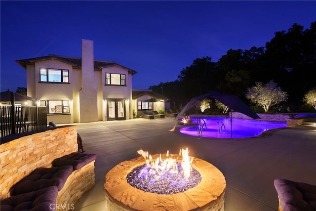 10270 Santa Ana Rd, Atascadero, CA 93422 - pool at night featuring an outdoor fire pit, a patio area, an outdoor pool, and french doors