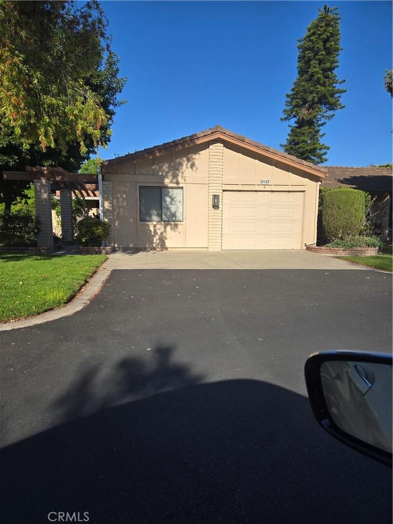3137 Via Vis Unit A, Laguna Woods, CA 92637 - view of front facade featuring a garage and driveway