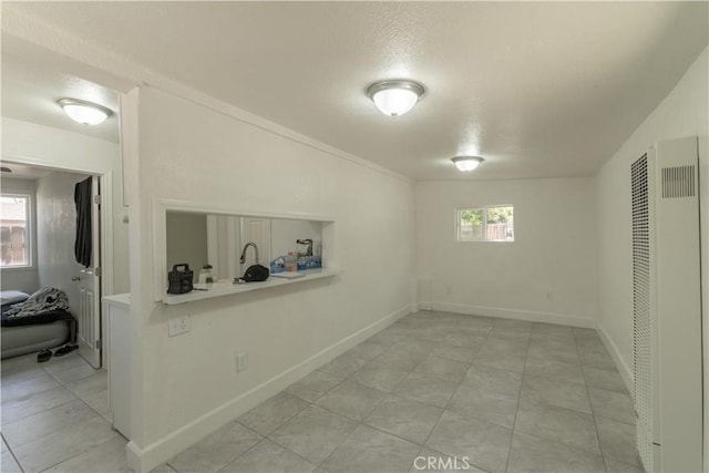 10010 Cedar Ave, Bloomington, CA 92316 - basement with a heating unit, plenty of natural light, a textured ceiling, and light tile patterned flooring