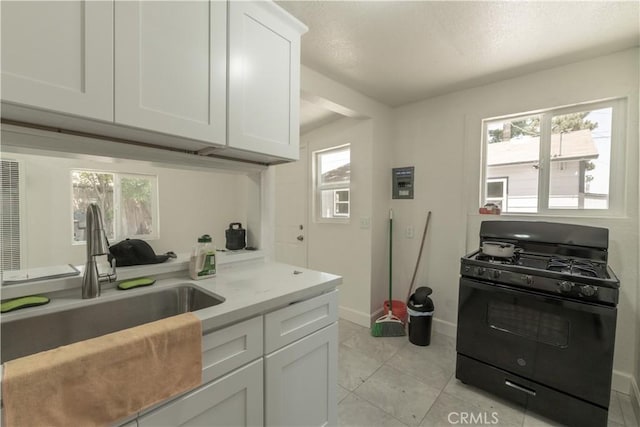 10010 Cedar Ave, Bloomington, CA 92316 - kitchen with black range with gas cooktop, light countertops, white cabinetry, and a textured ceiling