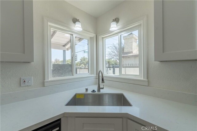 10010 Cedar Ave, Bloomington, CA 92316 - kitchen featuring white cabinets, light countertops, a textured wall, and dishwasher