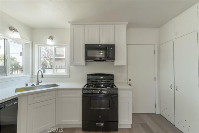 10010 Cedar Ave, Bloomington, CA 92316 - kitchen with black appliances, light wood-style floors, white cabinetry, and light countertops