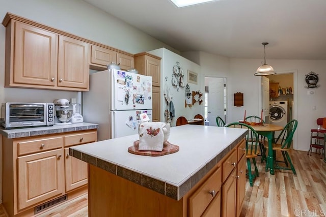 1750 W Citracado Pkwy Unit 157, Escondido, CA 92029 - kitchen with freestanding refrigerator, washer / dryer, light wood-type flooring, hanging light fixtures, and a kitchen island