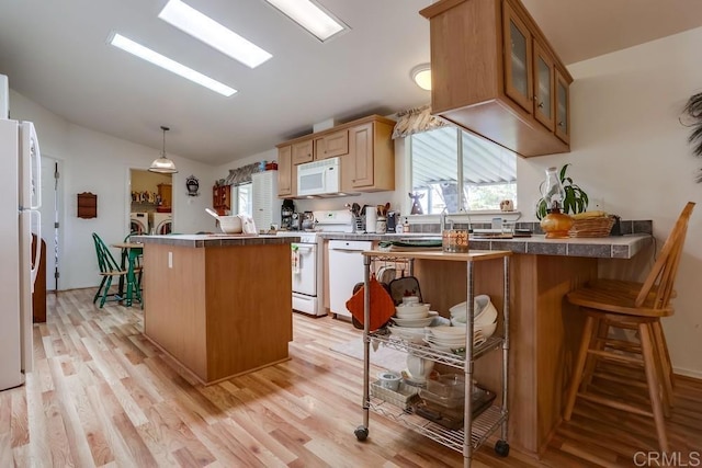 1750 W Citracado Pkwy Unit 157, Escondido, CA 92029 - kitchen featuring white appliances, lofted ceiling, washer and clothes dryer, a kitchen island, and glass insert cabinets