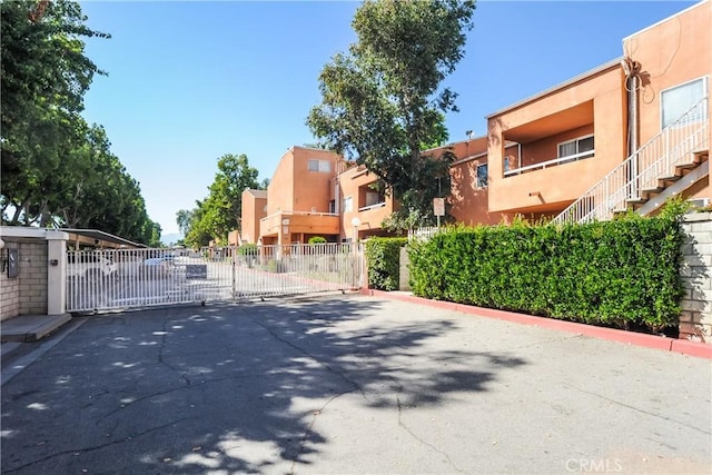 12601 Van Nuys Blvd Unit 103, Pacoima, CA 91331 - view of asphalt road featuring a gate, curbs, and a gated entry