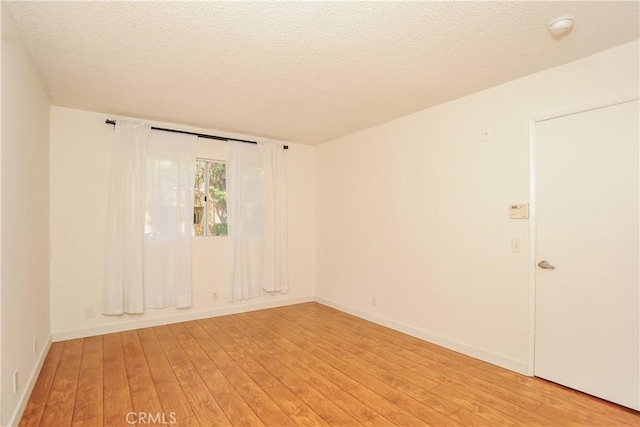 12601 Van Nuys Blvd Unit 103, Pacoima, CA 91331 - spare room with light wood finished floors, a smoke detector, and a textured ceiling