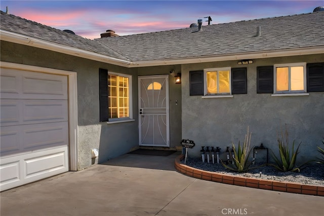 10480 Bryan St, Riverside, CA 92505 - exterior entry at dusk with a shingled roof and stucco siding