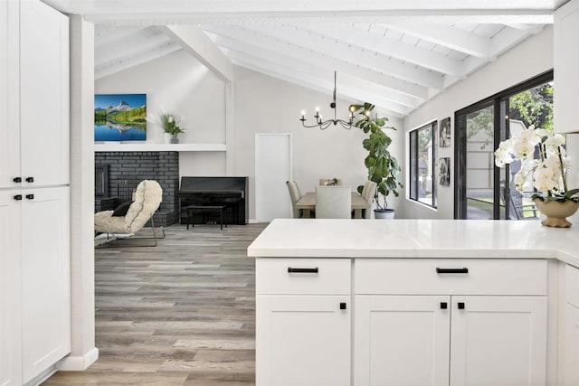 834 Cole Ranch Rd, Encinitas, CA 92024 - kitchen with a chandelier, white cabinetry, a fireplace, and light wood-type flooring