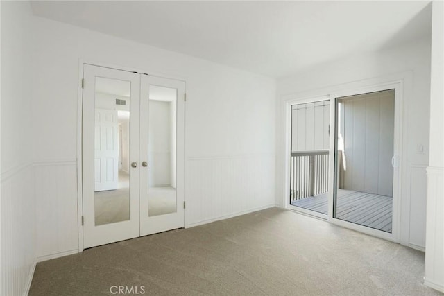 4440 Eagle Peak Rd Unit A, Concord, CA 94521 - unfurnished bedroom featuring carpet, a wainscoted wall, french doors, a decorative wall, and multiple closets