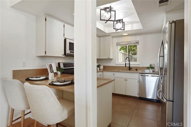 4440 Eagle Peak Rd Unit A, Concord, CA 94521 - kitchen with stainless steel appliances, a peninsula, a raised ceiling, and white cabinetry