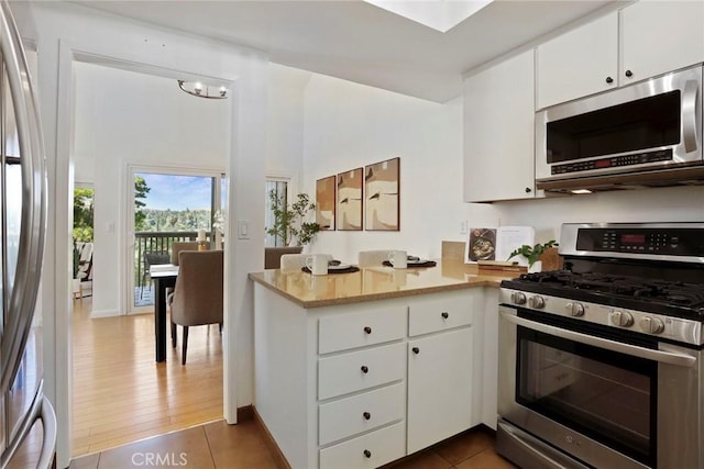 4440 Eagle Peak Rd Unit A, Concord, CA 94521 - kitchen featuring appliances with stainless steel finishes, a peninsula, white cabinetry, and tile patterned flooring