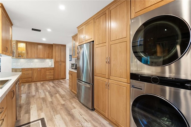 3654 4th Ave, La Crescenta, CA 91214 - kitchen with freestanding refrigerator, stacked washer / drying machine, light countertops, light wood-style floors, and backsplash