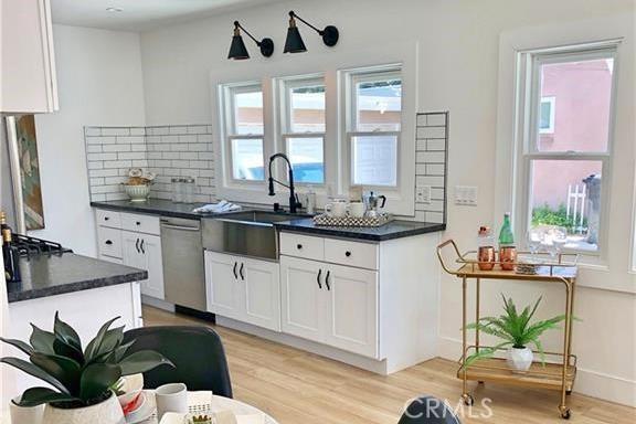 341 W Whiting Ave W, Fullerton, CA 92832 - kitchen featuring dishwasher, dark countertops, white cabinetry, and light wood-style flooring