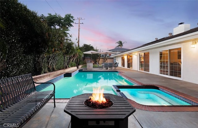 18921 Silver Maple Way N, Tustin, CA 92705 - pool at dusk featuring a patio area, a pool with connected hot tub, and an outdoor fire pit