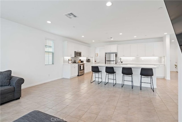421 Azalea St, Fillmore, CA 93015 - kitchen with stainless steel appliances, open floor plan, backsplash, a breakfast bar, and light countertops