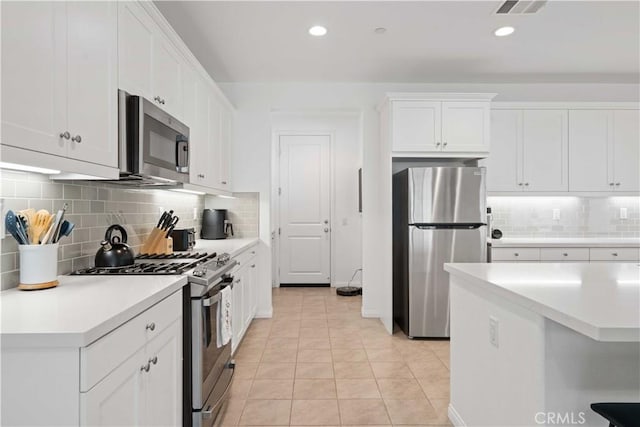 421 Azalea St, Fillmore, CA 93015 - kitchen with appliances with stainless steel finishes, decorative backsplash, light countertops, white cabinetry, and light tile patterned floors