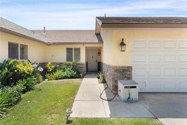 11116 Wayfield Rd, Riverside, CA 92505 - view of exterior entry featuring stucco siding, stone siding, a lawn, and an attached garage