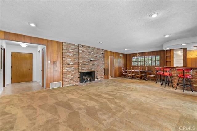 10868 Willowcrest Pl, Studio City, CA 91604 - living area featuring wood walls, a textured ceiling, carpet floors, a brick fireplace, and a bar