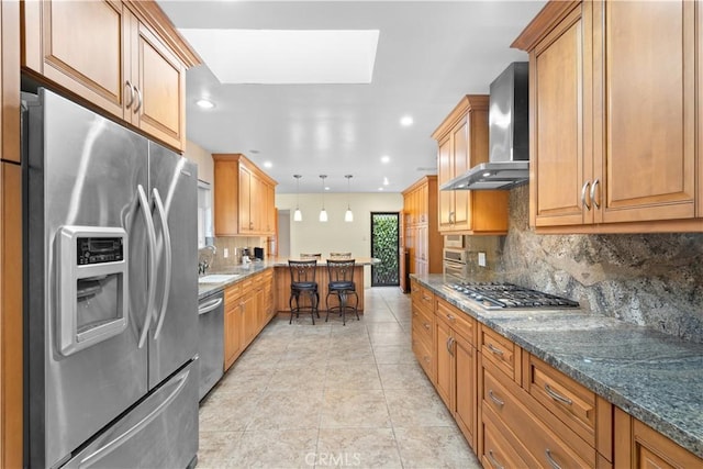 10868 Willowcrest Pl, Studio City, CA 91604 - kitchen with stainless steel appliances, wall chimney range hood, a peninsula, backsplash, and recessed lighting
