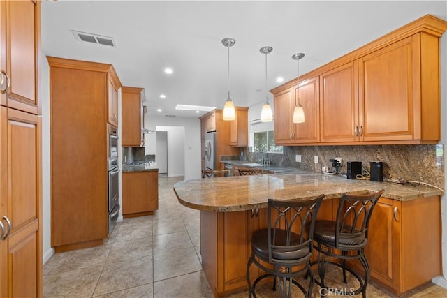 10868 Willowcrest Pl, Studio City, CA 91604 - kitchen featuring a peninsula, recessed lighting, backsplash, a kitchen breakfast bar, and appliances with stainless steel finishes