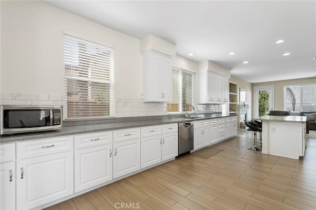 25 Vista Palermo, Lake Elsinore, CA 92532 - kitchen with stainless steel appliances, a breakfast bar, white cabinets, backsplash, and recessed lighting