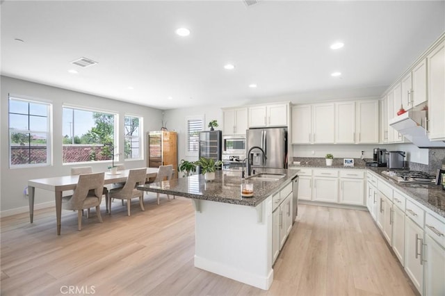 16138 Solitude Ave, Chino, CA 91708 - kitchen with stainless steel appliances, dark stone counters, light wood-type flooring, recessed lighting, and white cabinetry
