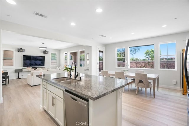 16138 Solitude Ave, Chino, CA 91708 - kitchen featuring stainless steel dishwasher, dark stone counters, light wood-style floors, recessed lighting, and a kitchen island with sink