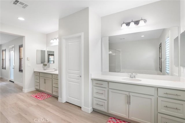 16138 Solitude Ave, Chino, CA 91708 - full bath featuring two vanities, wood finished floors, recessed lighting, and a shower