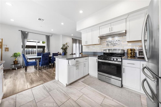418 N Dalton Ave, Azusa, CA 91702 - kitchen with appliances with stainless steel finishes, under cabinet range hood, a peninsula, dark countertops, and recessed lighting