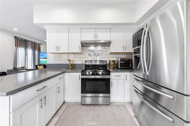 418 N Dalton Ave, Azusa, CA 91702 - kitchen featuring stainless steel appliances, under cabinet range hood, a peninsula, white cabinetry, and tasteful backsplash